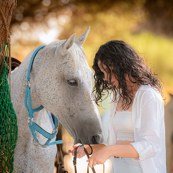 Chica acariciando caballo